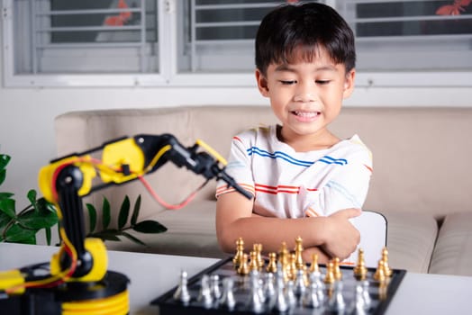 Asian little boy is playing chess with robot machine arm, STEM education E-learning, Funny children learning successful getting a lesson control robot arm, Technology science education concept