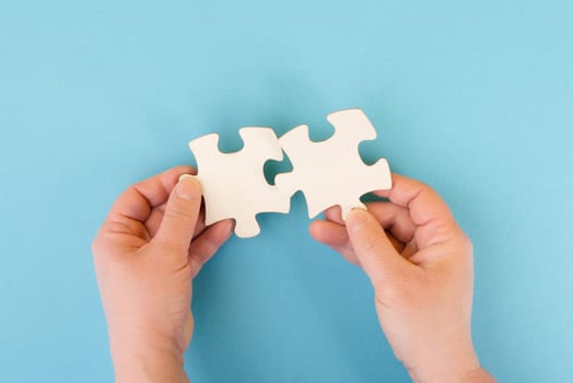 Holding two pieces of a puzzle in the hands, connecting together as a team, solving a problem, strategy and communication concept