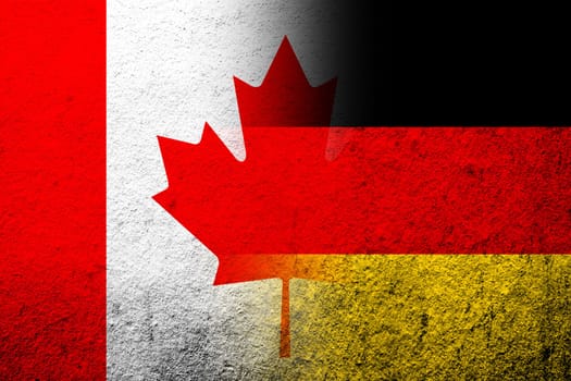 The national flag of Germany with National flag of Canada Maple Leaf. Grunge background