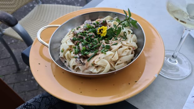 Tagliatelle pasta with mushrooms in a creamy sauce with parmesan and white wine, horizontal