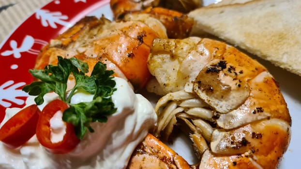 Traditional spanish tapa with prawns cooked in oil with garlic and chili. Served with slice baguette