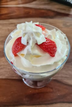Homemade strawberry ice cream made from fresh berries with basil in glass bowl on gray background. soft focus.