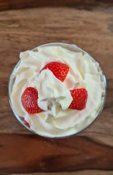 Homemade strawberry ice cream made from fresh berries with basil in glass bowl on gray background. soft focus.