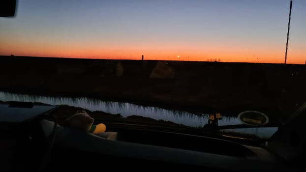 Camper van in the sunset in the background a Dutch windmill