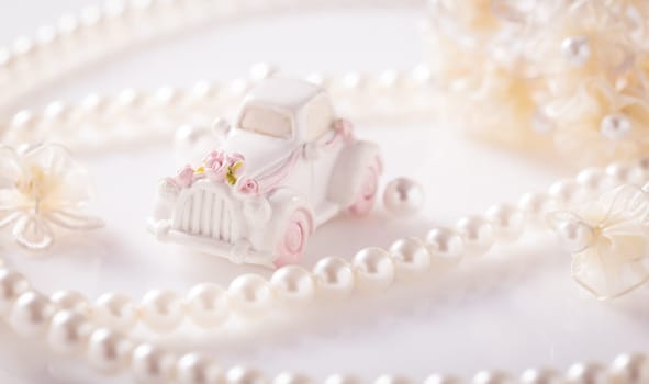 Wedding still life with golden rings and pearl necklace in white