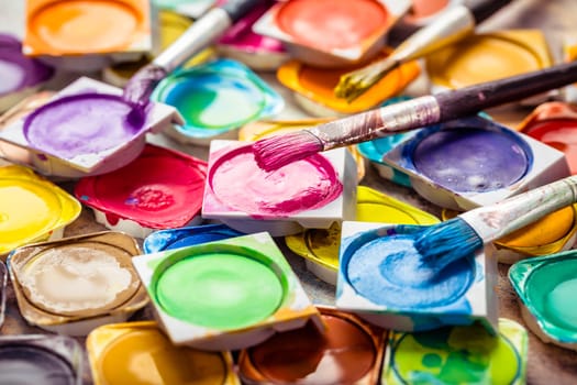Colors and brushes on wooden background