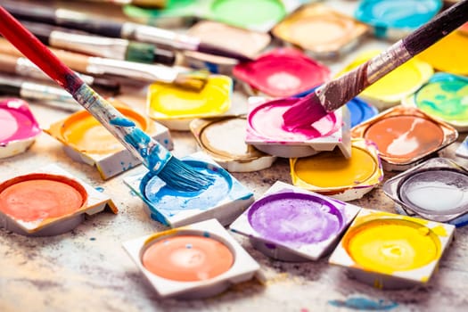 Colors and brushes on wooden background