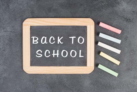 Chalkboard with the text back to school, education concept, colorful chalk