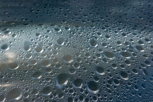 Kondenswasser-Tropfen bilden ein abstraktes Muster unter einer Plastikfolie