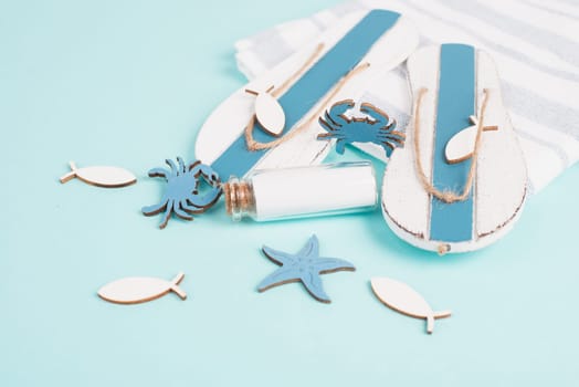 Blue colored summer and vacation background, flip flops, bottle and sea stars building a frame, copy space for text, holiday and tourism concept