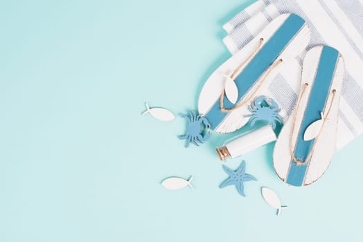 Blue colored summer and vacation background, flip flops, bottle and sea stars building a frame, copy space for text, holiday and tourism concept