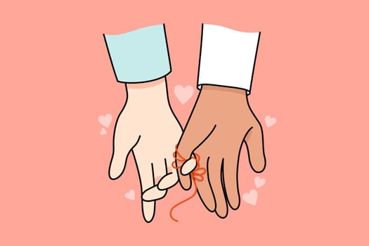 Multiracial couple hands linked with thread