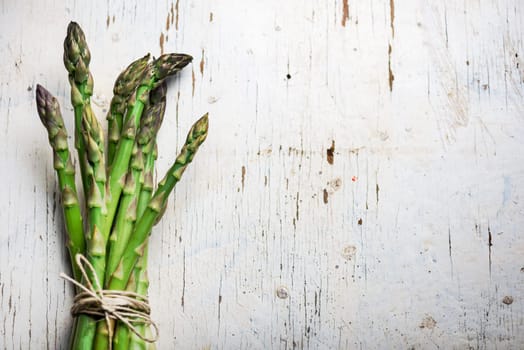 Fresh green asparagus on rustic white table