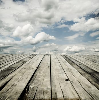 Rustic wooden planks and cloudy sky background design.