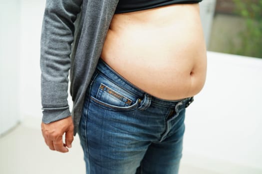 Asian woman show fat belly big size overweight and obesity at office.