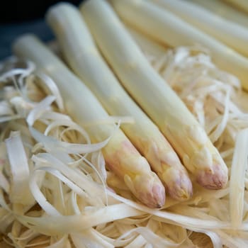 Peeled white asparagus on a kitchen table