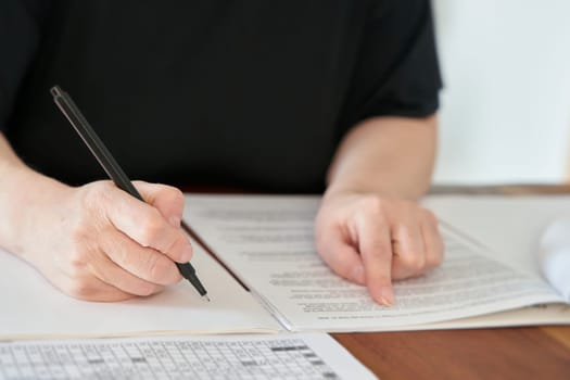 Close up of hand with pen writing at desk in office
