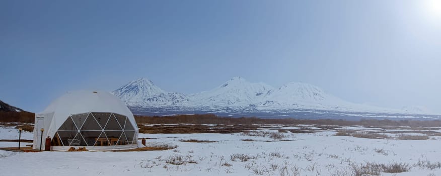 The Glamping house and volcano, rural landscape, tent houses in Kamchatka peninsula. Selective focus.