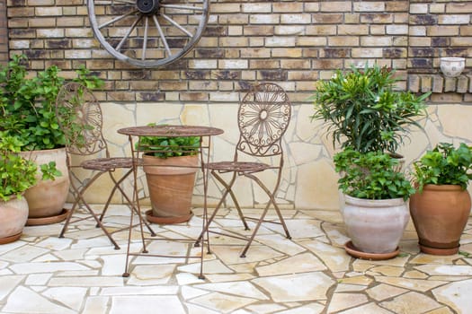 beautiful place in the garden in the mediterranean style, brick wall and pots with flowers