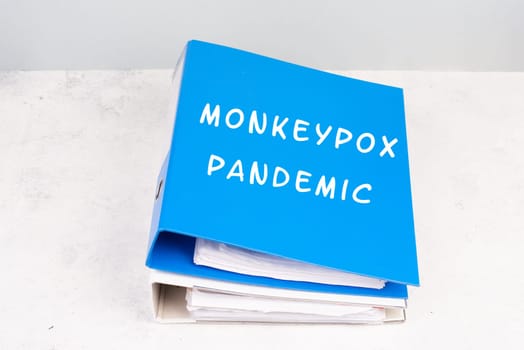 The words monkeypox pandemic are standing in german language on a folder, outbreak of the MPXV virus, infectious disease spreading