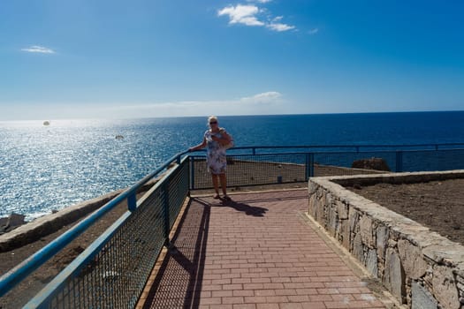 Businesswoman in sunglasses on the beach. she is happy about the sea and the sun. The sea air breathes in a sexy white dress