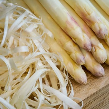 Peeled white asparagus on a kitchen table