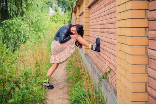 A young girl put her foot on a brick fence in the park