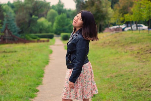 young pretty brunette woman with beautiful long hair in the park
