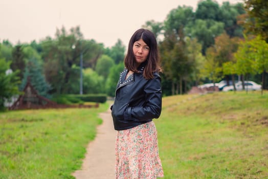 beautiful white brunette woman walking alone in green park