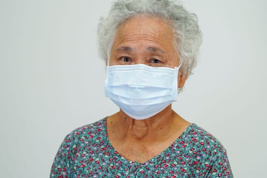 Asian elderly woman patient wearing a mask for protect Covid-19 Coronavirus.