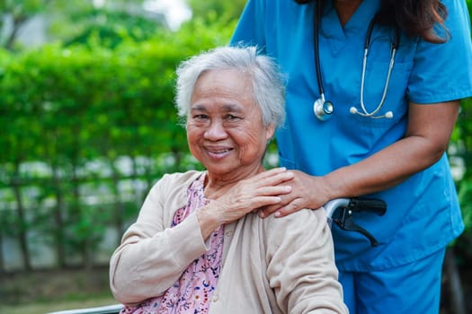 Doctor help Asian elderly woman disability patient sitting on wheelchair in park, medical concept.