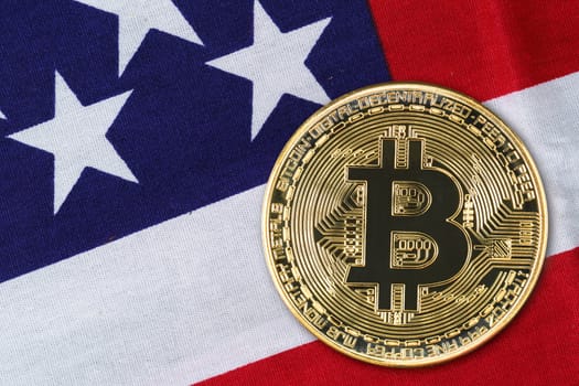 Close up Crypto currency concept. Gold Bitcoin coin on flag of United States of America USA