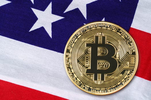 Close up Crypto currency concept. Gold Bitcoin coin on flag of United States of America USA