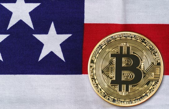 Close up Crypto currency concept. Gold Bitcoin coin on flag of United States of America USA