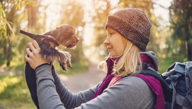 Young woman with dog in nature in the forest. Concept of tourism and friendship.