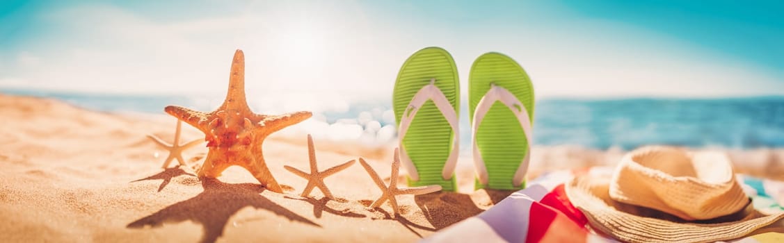 Beach accessories on the sand of the seacoast in summertime. Concept of the vacation and tourism.