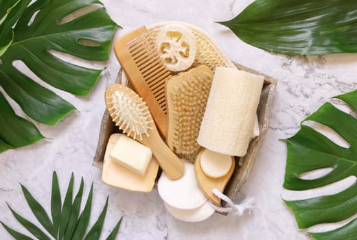 Homemade organic cosmetics and eco friendly accessories near monstera leaves flat lay, copy space. Brand packaging mockup. Natural beauty products for hair and skin care, Top view