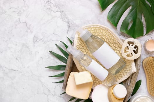 Homemade organic cosmetics and eco friendly accessories near monstera leaves flat lay, copy space. Brand packaging mockup. Natural beauty products for hair and skin care, Top view