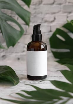 Brown one pump dispenser and tropical monstera leaves on marble table close up. Brand packaging mockup. Skincare beauty product. Natural herbal cosmetics concept..