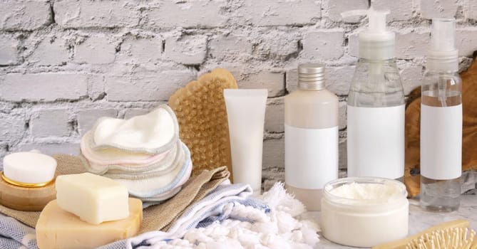 Homemade Skin care cosmetics and bath accessories against white brick wall close up. Brand packaging mockup. Organic beauty products. Home Spa concept..