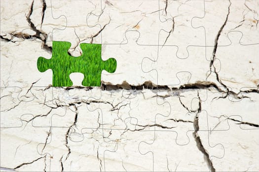 Cracked dry background as a puzzle and green grass