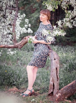 Young woman portrait on blooming apple trees background