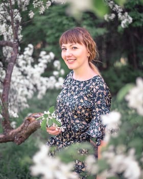 Young woman portrait on blooming apple trees background