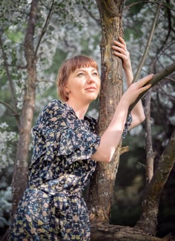 Young woman portrait on blooming apple trees background