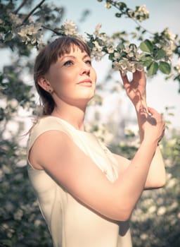 Young woman portrait on blooming apple trees background