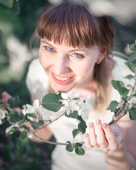 Young woman portrait on blooming apple trees background