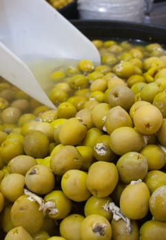 Pickled olives stuffed with vinegar pickled anchovies. Delicious pickled snack displayed plastic basket