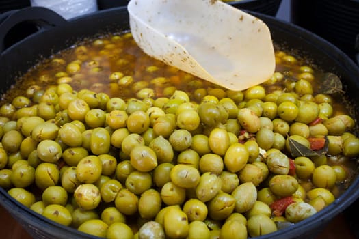 Crushed marinated olives. Delicious pickled snack displayed plastic basket