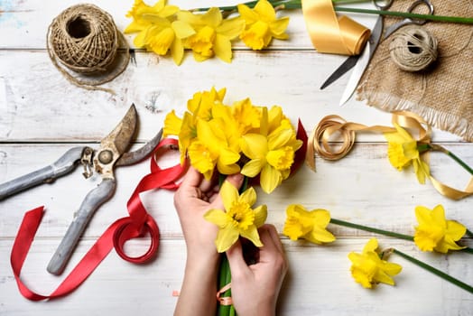 Woman making bouquet of narcissus