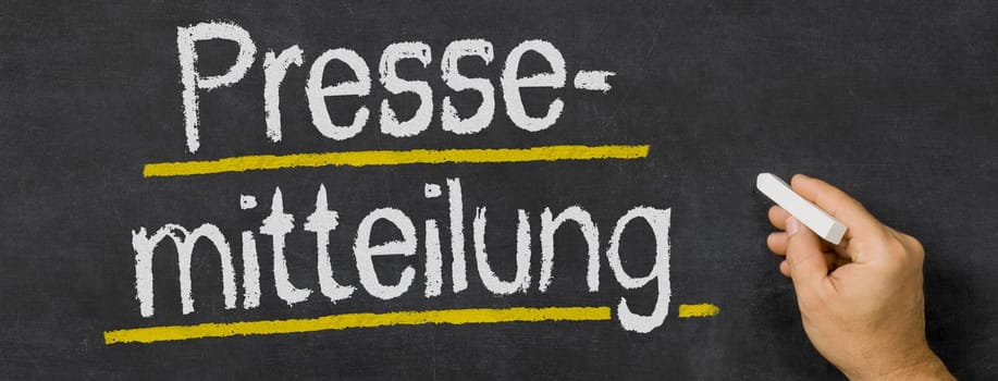 Text written on a blackboard - Press release in german - Pressemitteilung